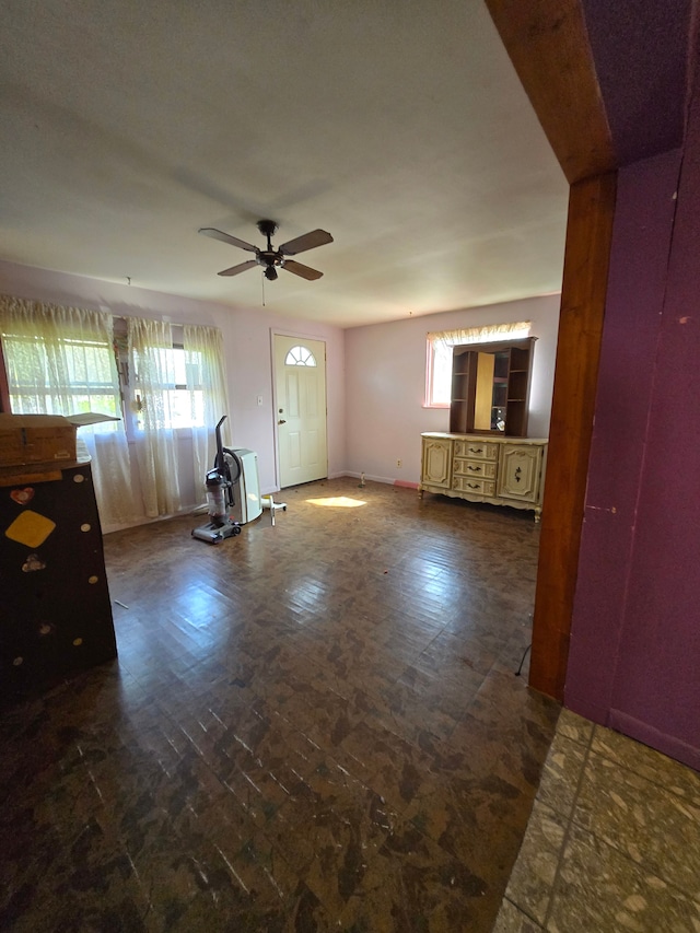 unfurnished living room with baseboards and a ceiling fan