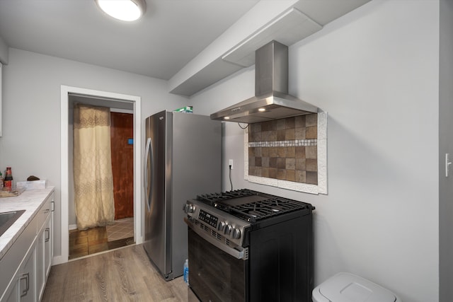 kitchen with stainless steel appliances, light wood-type flooring, white cabinetry, exhaust hood, and light countertops