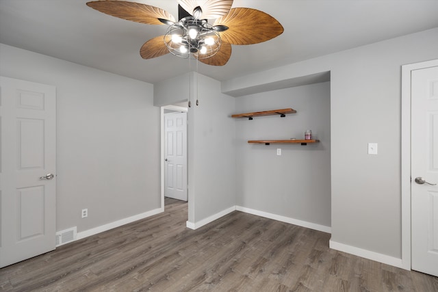 unfurnished bedroom with baseboards, ceiling fan, visible vents, and wood finished floors