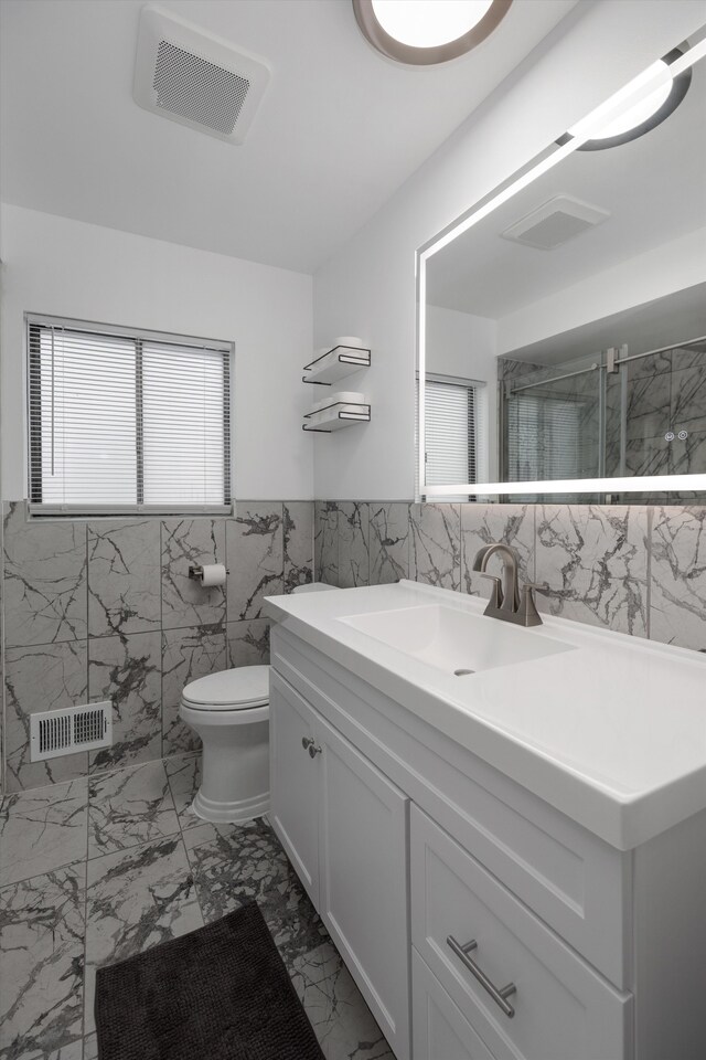 full bathroom featuring marble finish floor, tile walls, visible vents, and a marble finish shower
