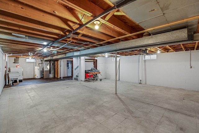 unfinished below grade area with a sink and gas water heater