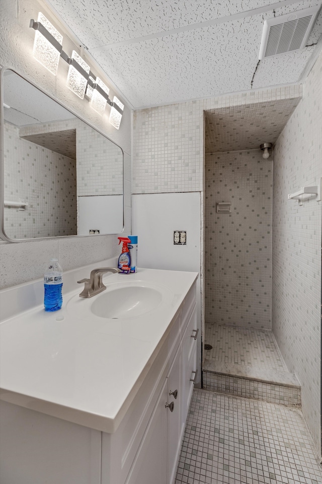 bathroom with a stall shower, tile patterned floors, vanity, and visible vents