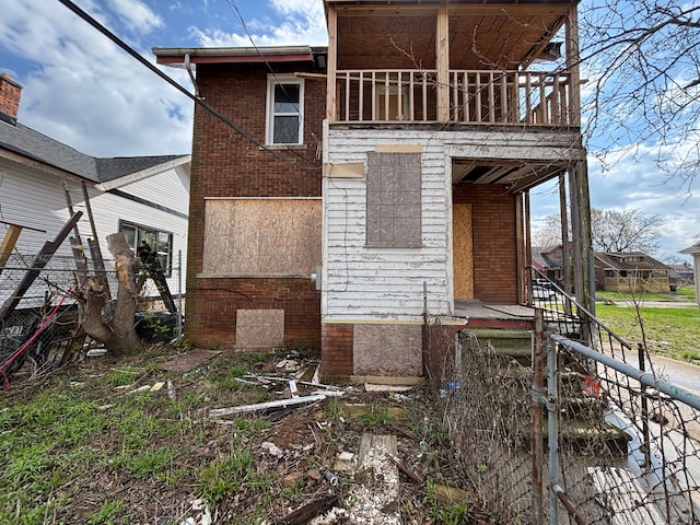 exterior space featuring brick siding and a balcony