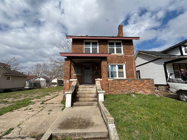 view of front of property featuring a chimney and brick siding