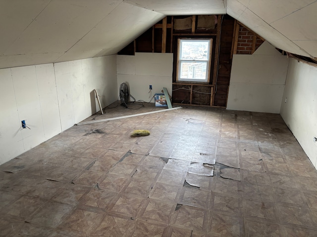 additional living space featuring lofted ceiling and wood walls