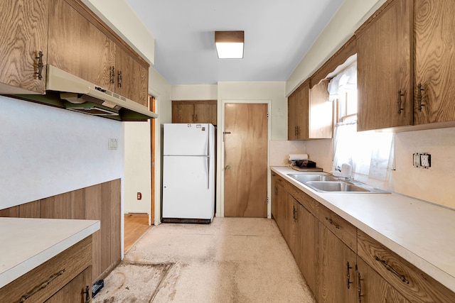 23022 Lexington Ave, Eastpointe, MI 48021 - kitchen featuring freestanding refrigerator, brown cabinets, under cabinet range hood, and a sink