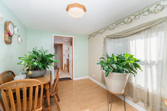 dining room with light wood-type flooring and baseboards