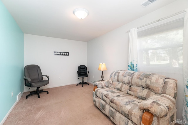 living area featuring light colored carpet and baseboards