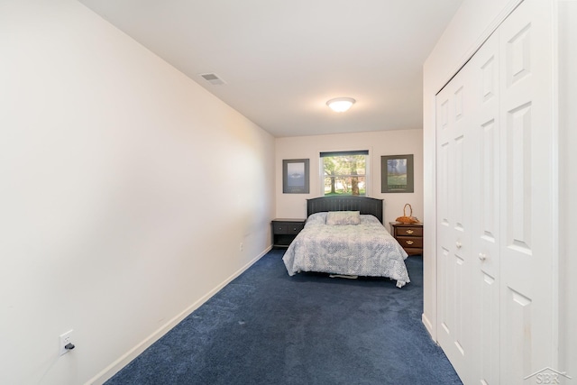bedroom with dark carpet and baseboards
