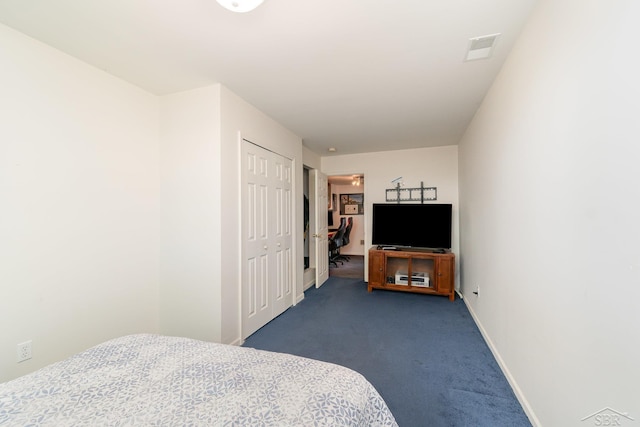 bedroom featuring dark carpet, baseboards, and a closet