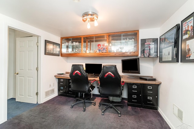 office with dark carpet and baseboards