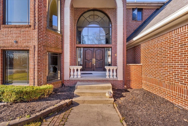 doorway to property with brick siding and covered porch