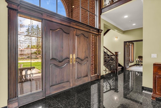 entryway with stairway, ornamental molding, baseboards, and granite finish floor