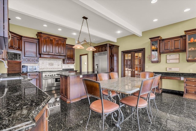 kitchen featuring a sink, built in appliances, granite finish floor, and recessed lighting