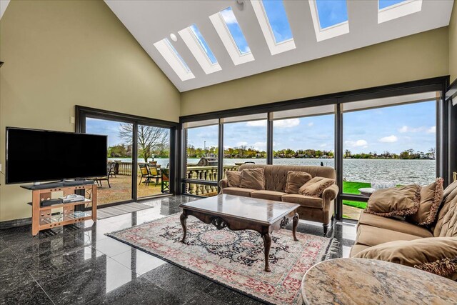 living room with a water view, granite finish floor, high vaulted ceiling, a skylight, and baseboards