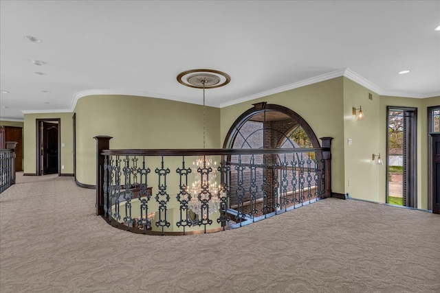 hall with ornamental molding, carpet, baseboards, and plenty of natural light