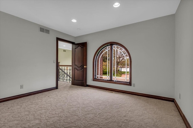 empty room featuring carpet flooring, baseboards, visible vents, and recessed lighting