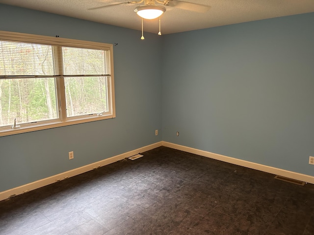 spare room with visible vents, baseboards, and a ceiling fan