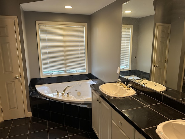 bathroom with a sink, a whirlpool tub, and tile patterned floors