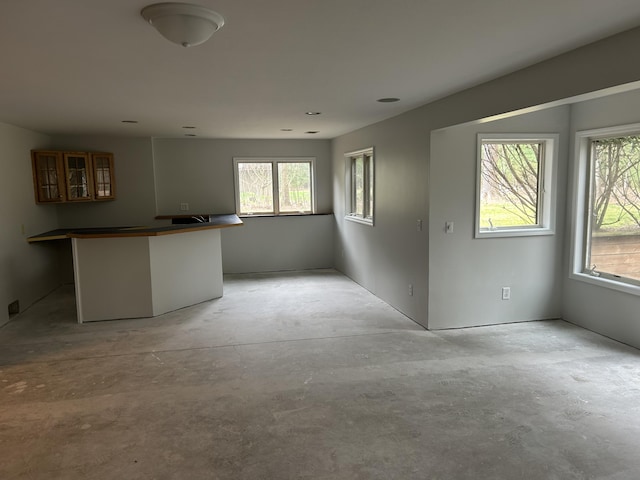 unfurnished room featuring plenty of natural light and concrete flooring
