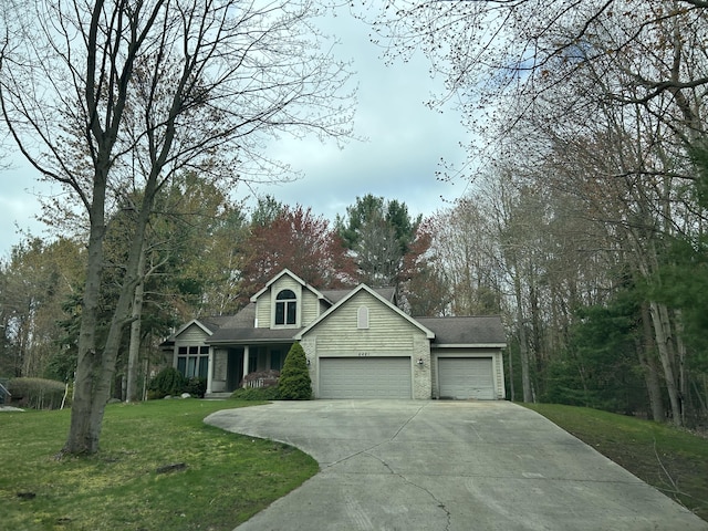 view of front of home with a front yard, a garage, and driveway