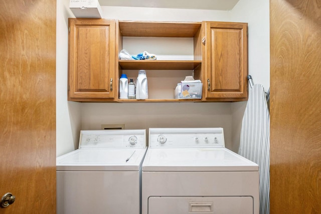 washroom with cabinet space and washer and clothes dryer
