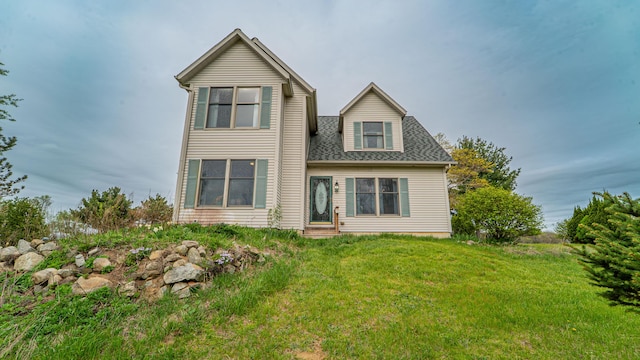 rear view of property with a yard and a shingled roof