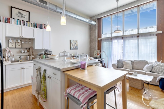 kitchen featuring white cabinetry, a healthy amount of sunlight, and a sink