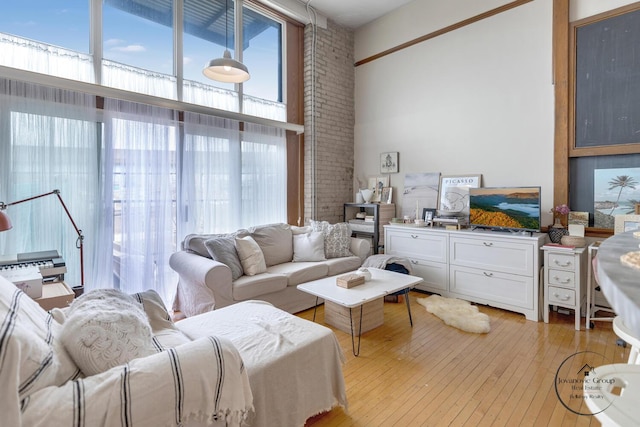 living area featuring light wood-style flooring and a high ceiling
