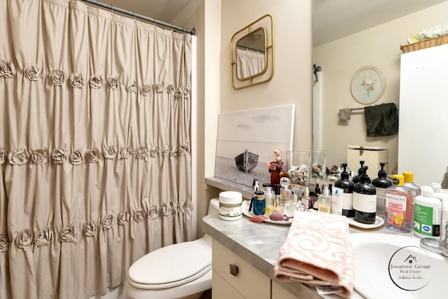 full bathroom featuring curtained shower, vanity, and toilet