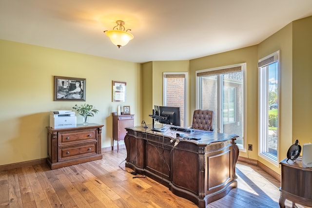 office area with light wood-style floors and baseboards