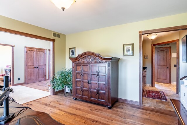 foyer entrance with light wood-style flooring and baseboards