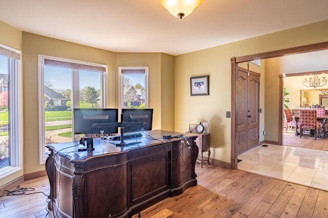 office area featuring light wood-style floors, baseboards, and a chandelier