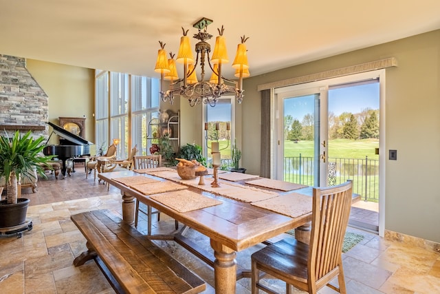 dining area with stone tile floors, a chandelier, and healthy amount of natural light