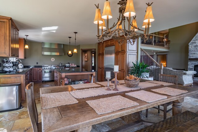 dining space featuring stone finish flooring, stairs, and a fireplace