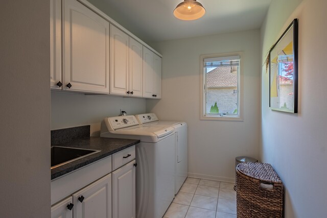 washroom with cabinet space, washer and clothes dryer, and light tile patterned floors