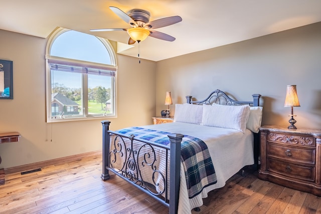 bedroom featuring hardwood / wood-style flooring, ceiling fan, and baseboards