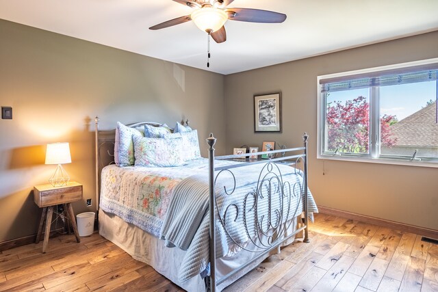 bedroom with hardwood / wood-style flooring, baseboards, and ceiling fan