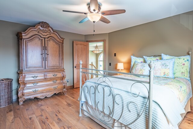 bedroom featuring light wood-type flooring, baseboards, and a ceiling fan