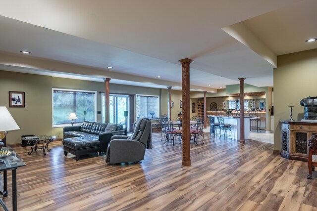 living area with ornate columns, wood finished floors, recessed lighting, and baseboards