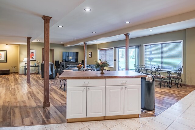 kitchen featuring decorative columns, recessed lighting, a center island, and white cabinets