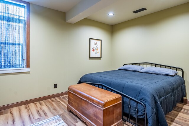 bedroom featuring wood finished floors, baseboards, and recessed lighting