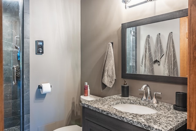 bathroom featuring toilet, vanity, and a tile shower