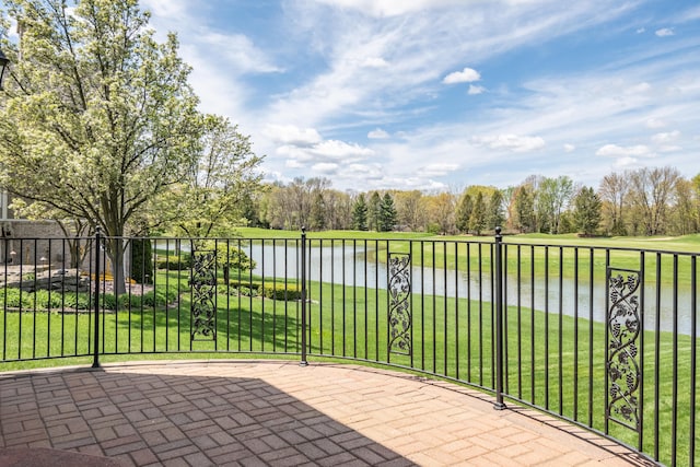 view of patio with a water view and view of wooded area