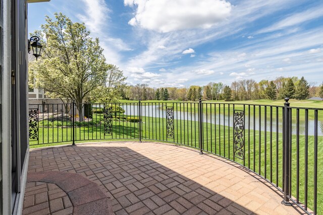 view of patio / terrace with a water view and view of wooded area