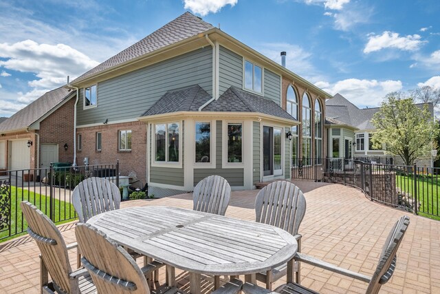 back of house with outdoor dining space, fence, a patio area, and roof with shingles