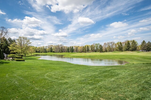 water view featuring a golf club and a tree filled landscape