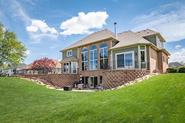 rear view of house with brick siding, a patio area, stairs, and a yard