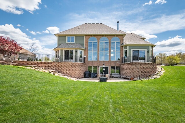 back of property featuring a patio, a yard, and roof with shingles