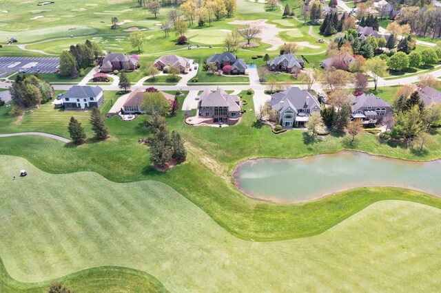 view of property location with a nearby body of water, a golf course, and nearby suburban area